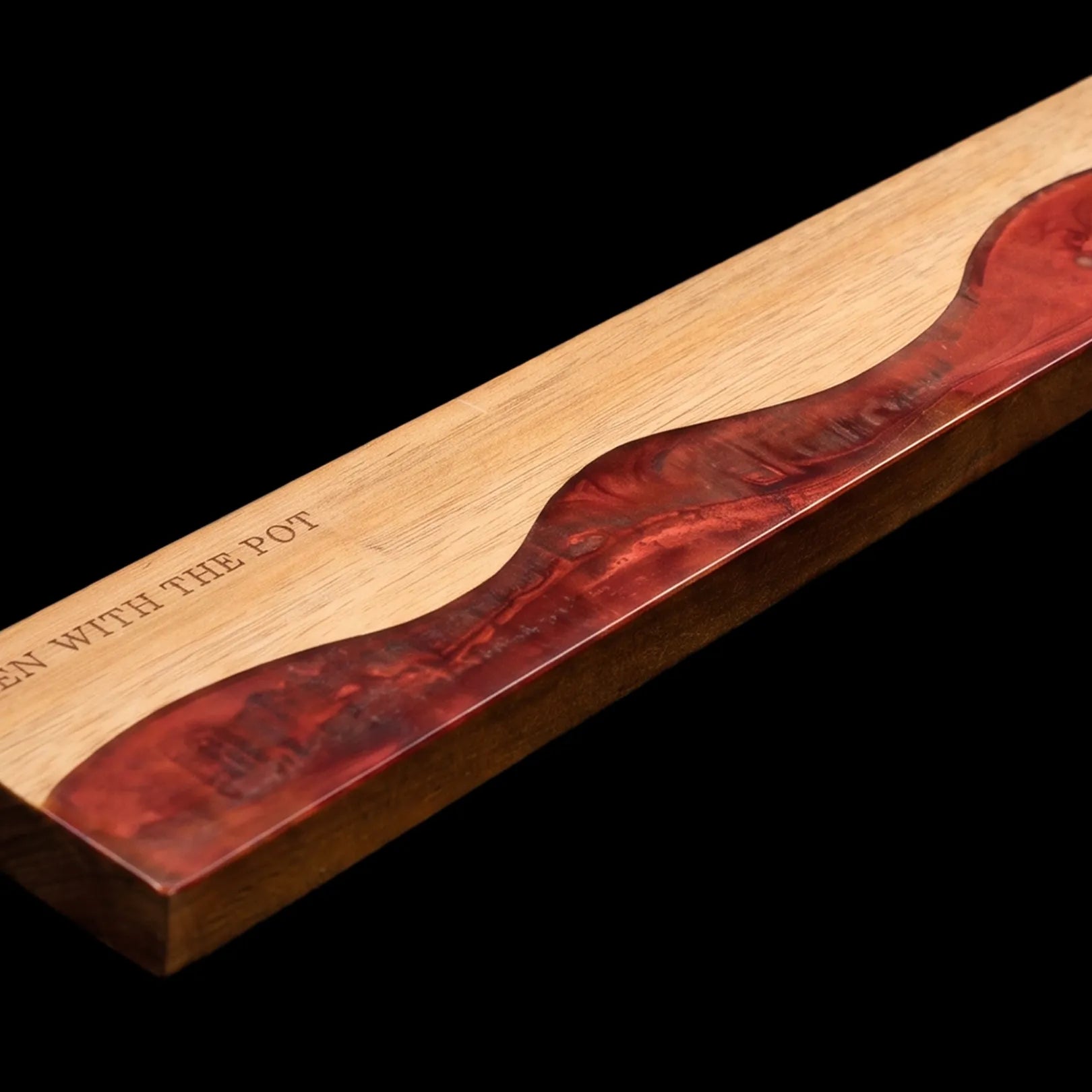 Close-up of the ember-red resin river detail in the acacia knife strip