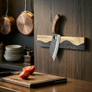 obsidian-black magnetic knife strip mounted in a kitchen with a knife attached