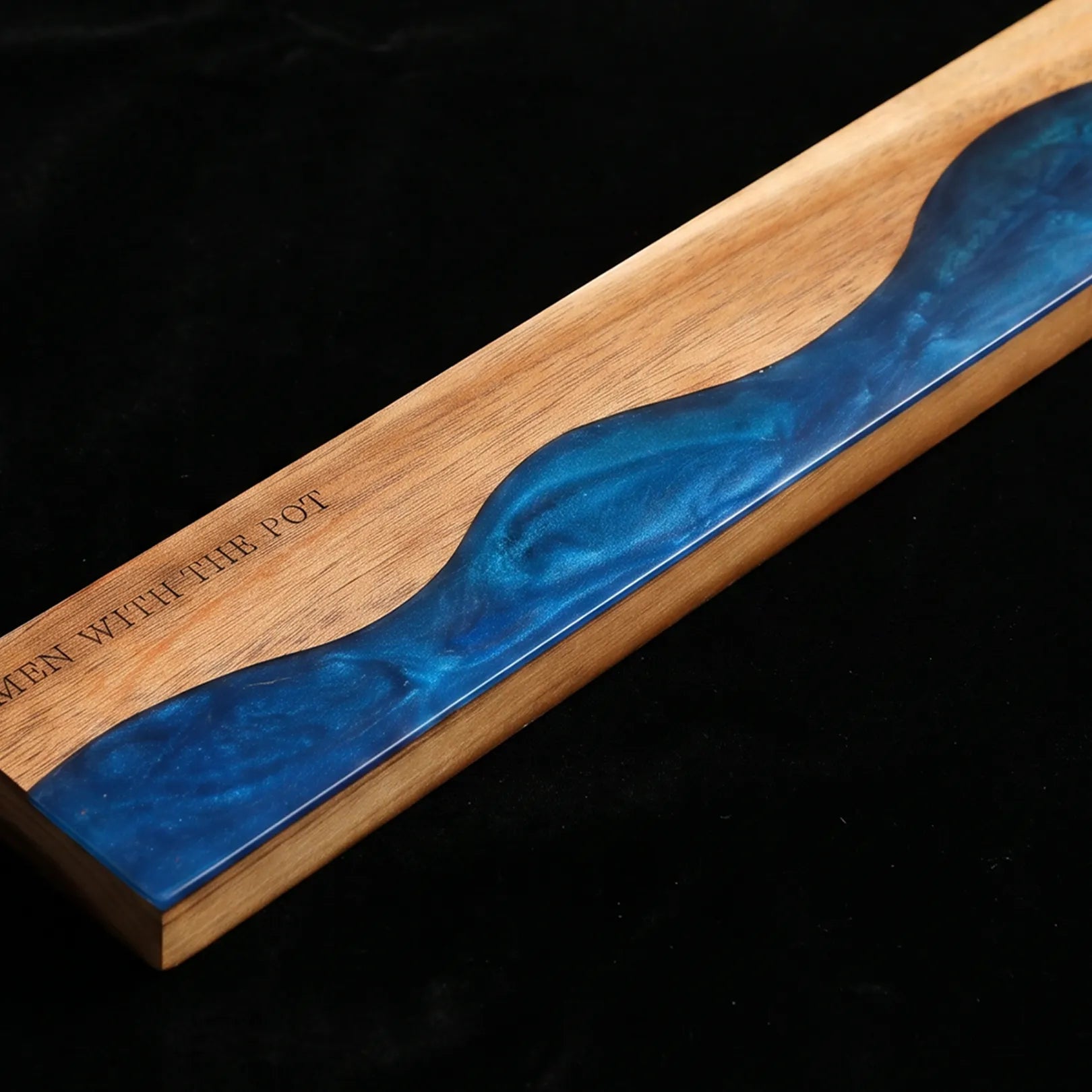 Close-up of the ocean-blue resin river detail in the acacia knife strip