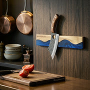 ocean-blue magnetic knife strip mounted in a kitchen with a knife attached