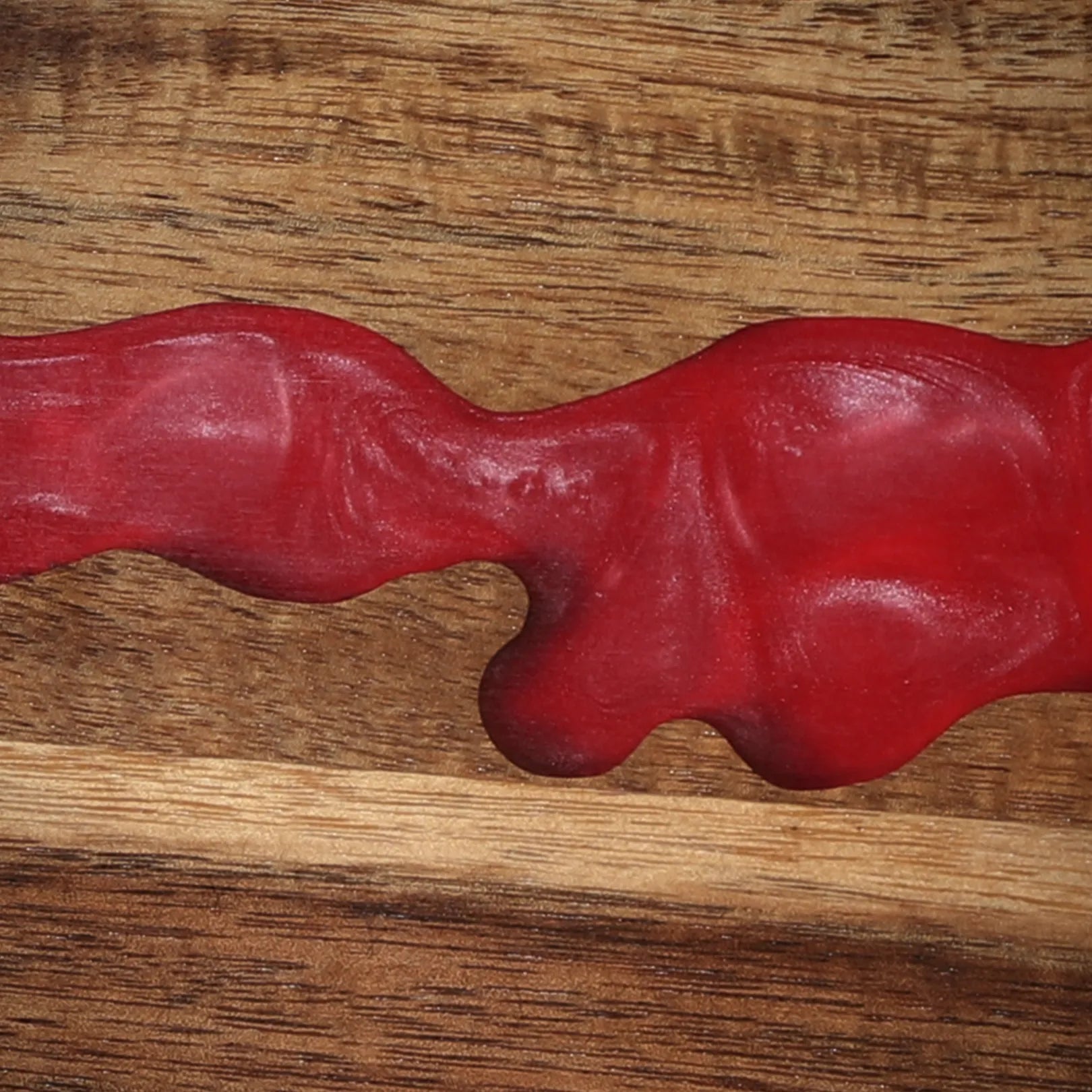 Close-up of the ember-red resin river detail in the acacia magnetic knife block