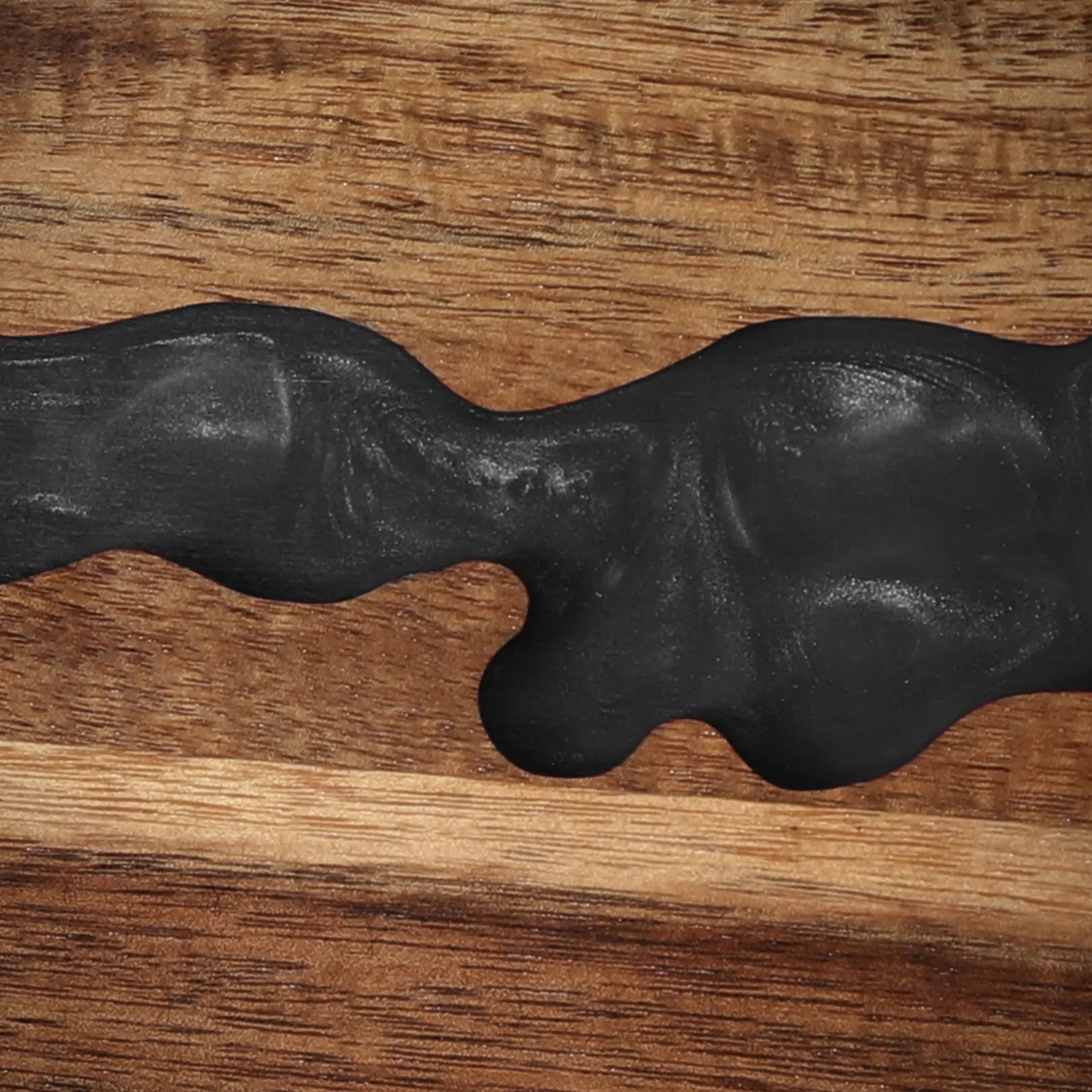 Close-up of the obsidian-black resin river detail in the acacia magnetic knife block