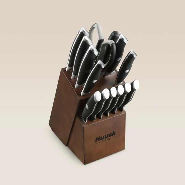 Huusk 14-piece black kitchen knife set arranged in an Acacia wood knife block