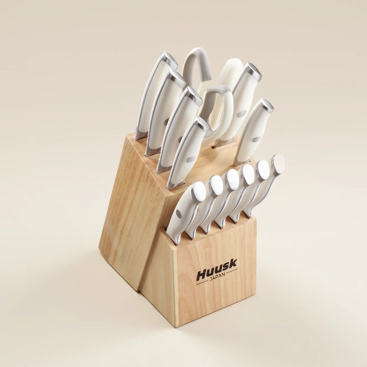 Huusk 14-piece white kitchen knife set arranged with a wooden knife block, kitchen shears, and sharpening rod