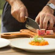 Cook using a compact Huusk utility knife to slice tuna into even portions.