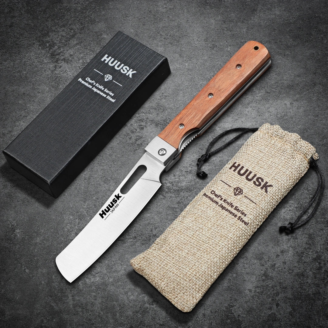 Open Huusk natural wood folding cleaver displayed with its gift box and storage pouch.