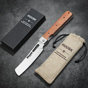Open Huusk natural wood folding cleaver displayed with its gift box and storage pouch.