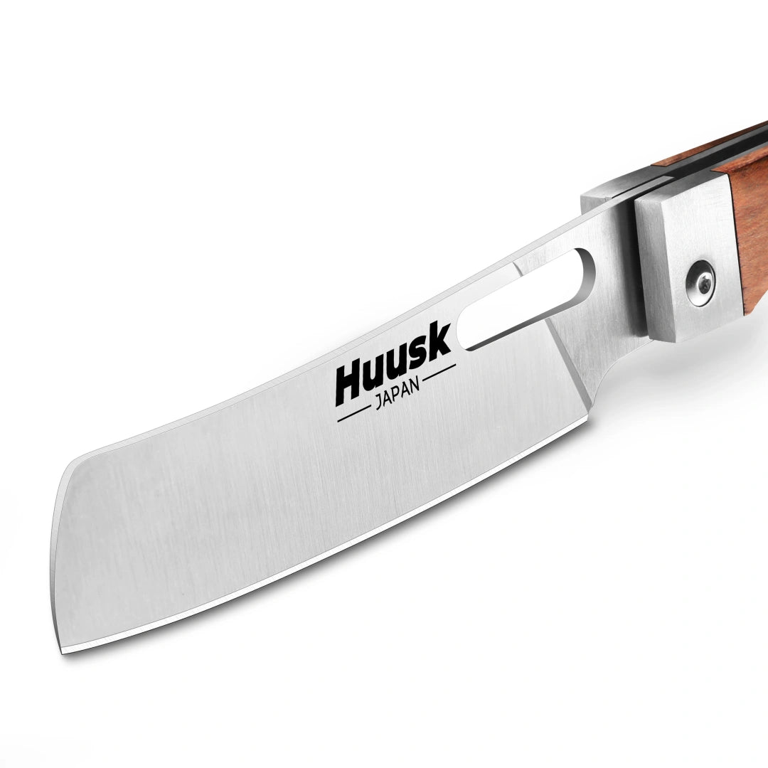 Close-up of the polished Huusk folding cleaver blade and natural wood pivot.