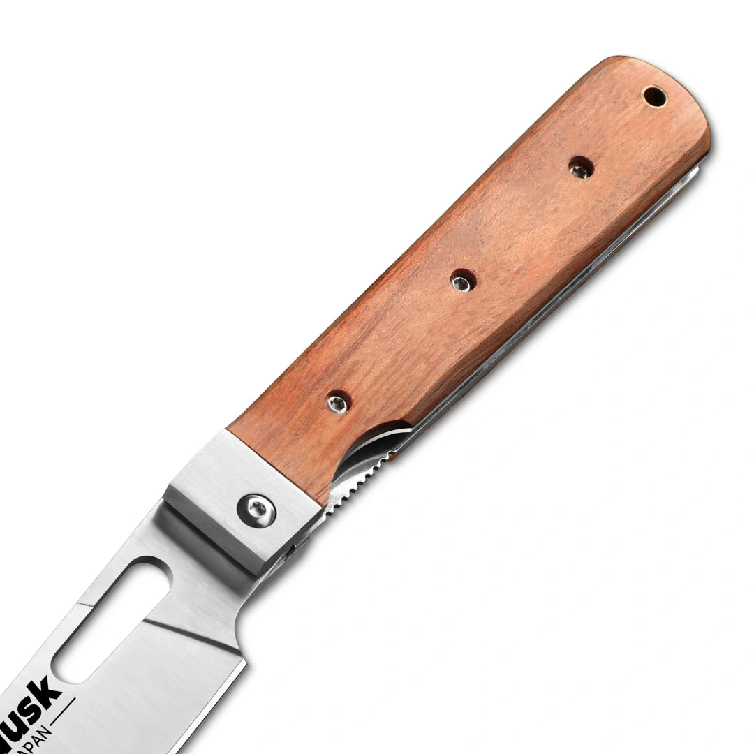 Close-up of the Huusk folding cleaver pivot, blade slot, and natural wood handle.