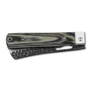 Huusk camo folding bread knife closed with the serrated blade stored in the handle.