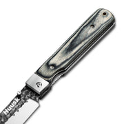 Close-up of the Huusk camo folding chef knife pivot and handle grain.