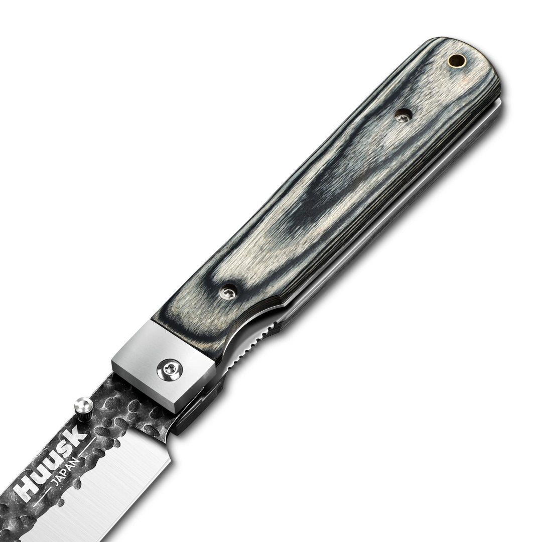 Close-up of the Huusk camo folding chef knife pivot and handle grain.