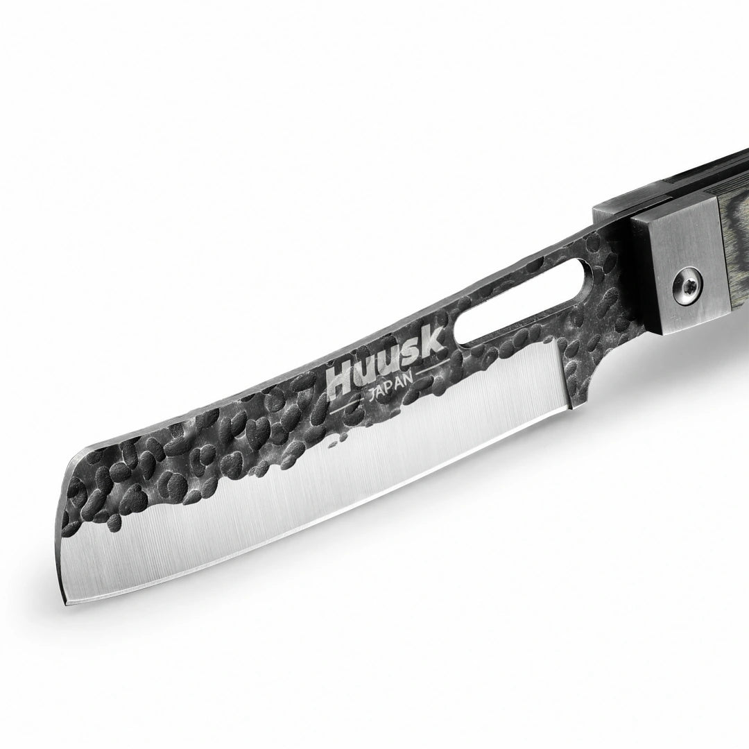 Close-up of the Huusk camo folding cleaver blade with hammered black finish.