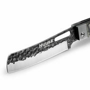 Close-up of the Huusk camo folding cleaver blade with hammered black finish.