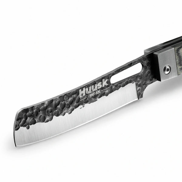 Close-up of the Huusk camo folding cleaver blade with hammered black finish.