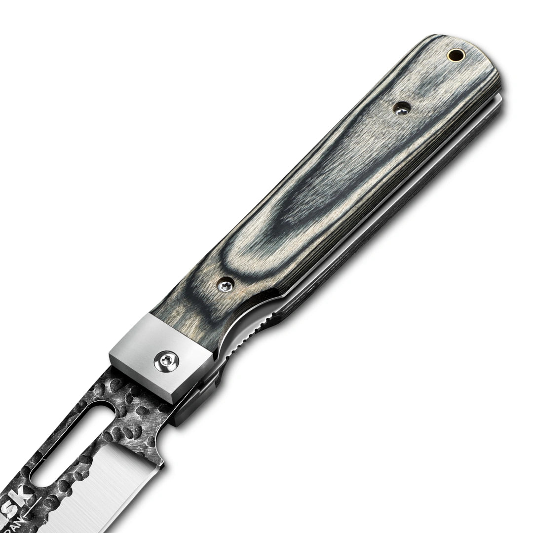 Close-up of the Huusk camo folding cleaver pivot, spine, and textured handle.