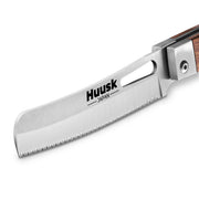 Close-up of the Huusk natural wood folding bread knife's serrated blade.