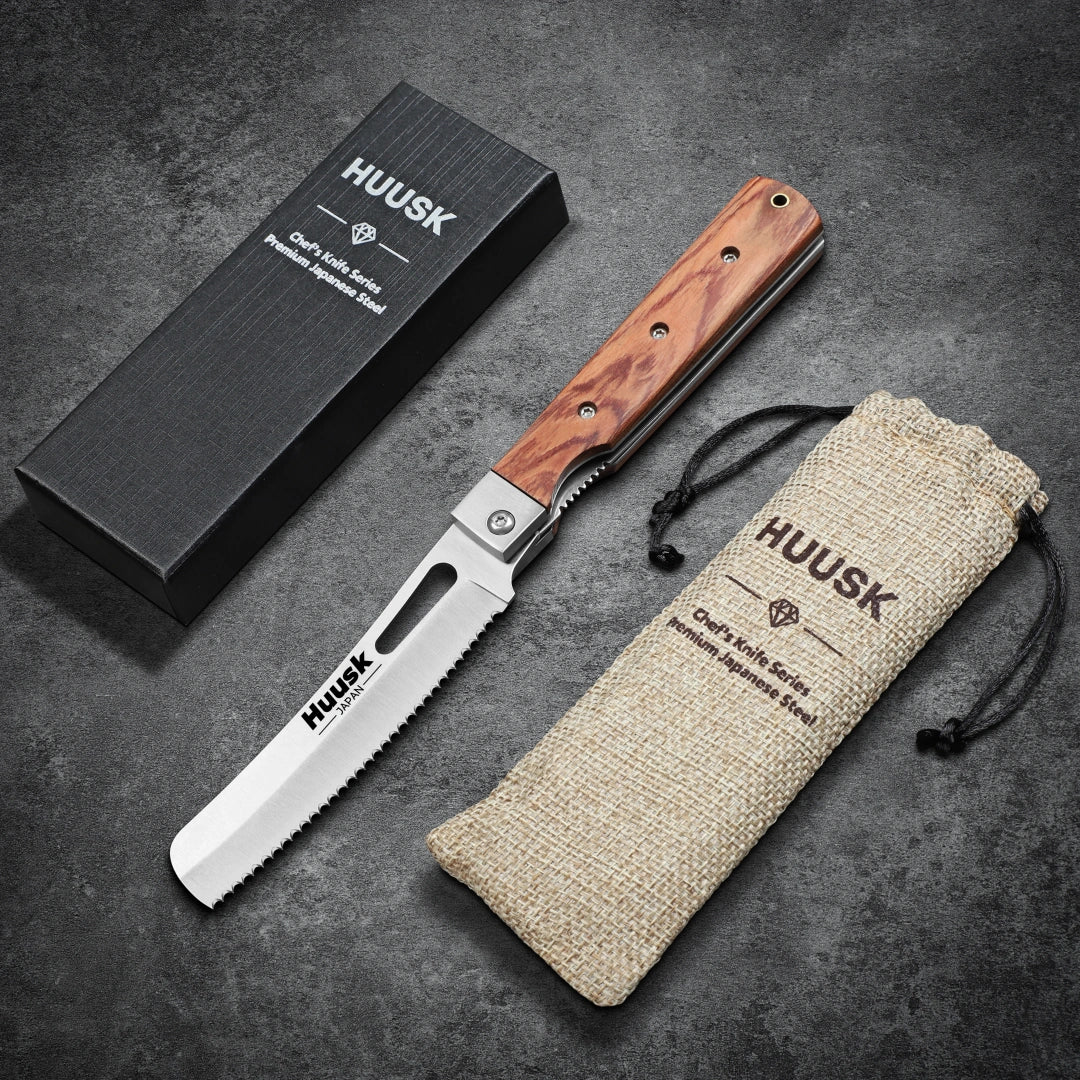 Huusk natural wood folding bread knife displayed open with its box and storage pouch.
