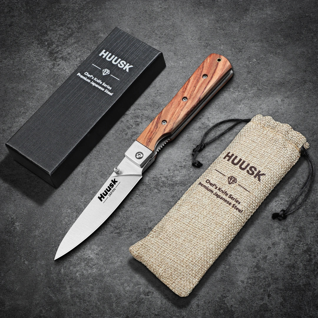Huusk natural wood folding paring knife displayed with its gift box and storage pouch.