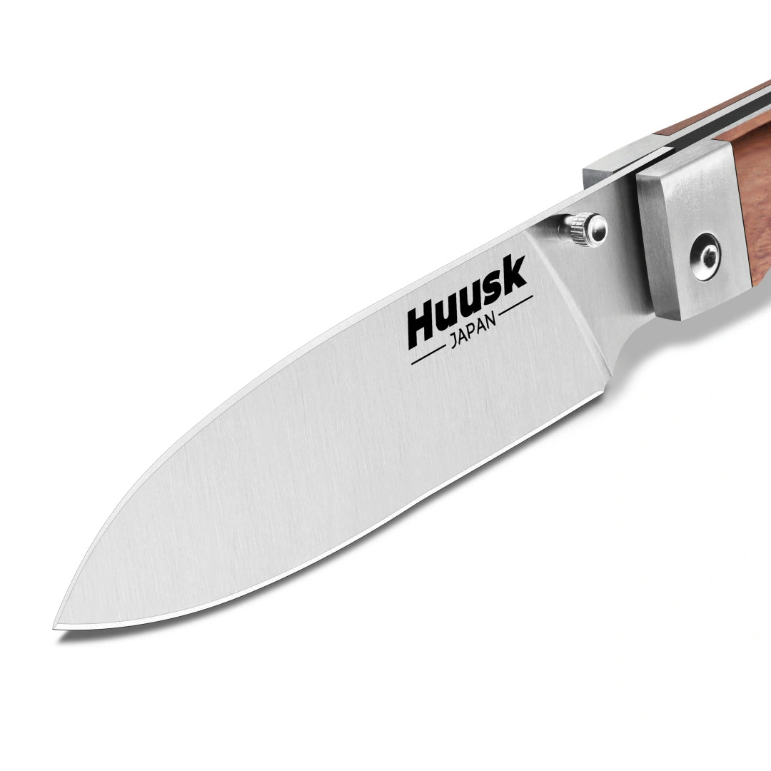 Close-up of the Huusk natural wood folding chef knife's polished blade.