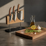 Double-sided magnetic knife stand holding three knives on a kitchen counter